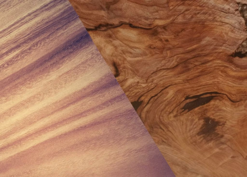 A wooden surface with two distinct wood grains, one light and one dark, is positioned against a black background.