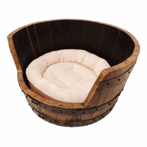 A rustic wooden dog bed, featuring a round shape, curved roof, and metal accents, rests inside a wooden barrel against a white background.