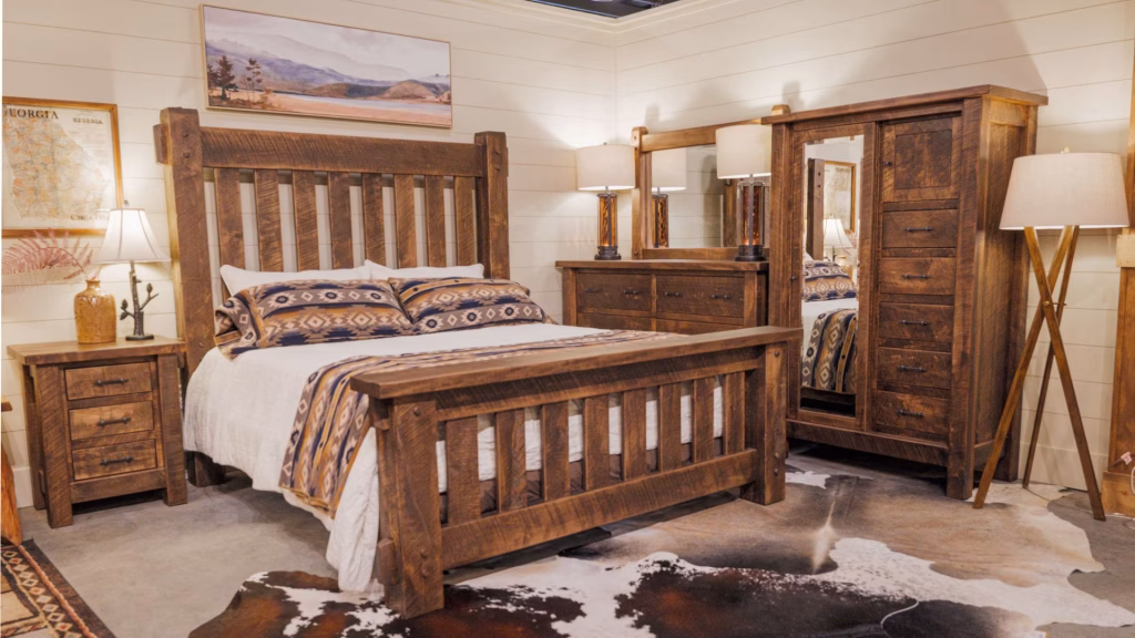 A rustic bedroom features a wooden bed with a white comforter and geometric pillows, a wooden dresser, a painting, and a cowhide rug, exuding a cozy and adventurous vibe.