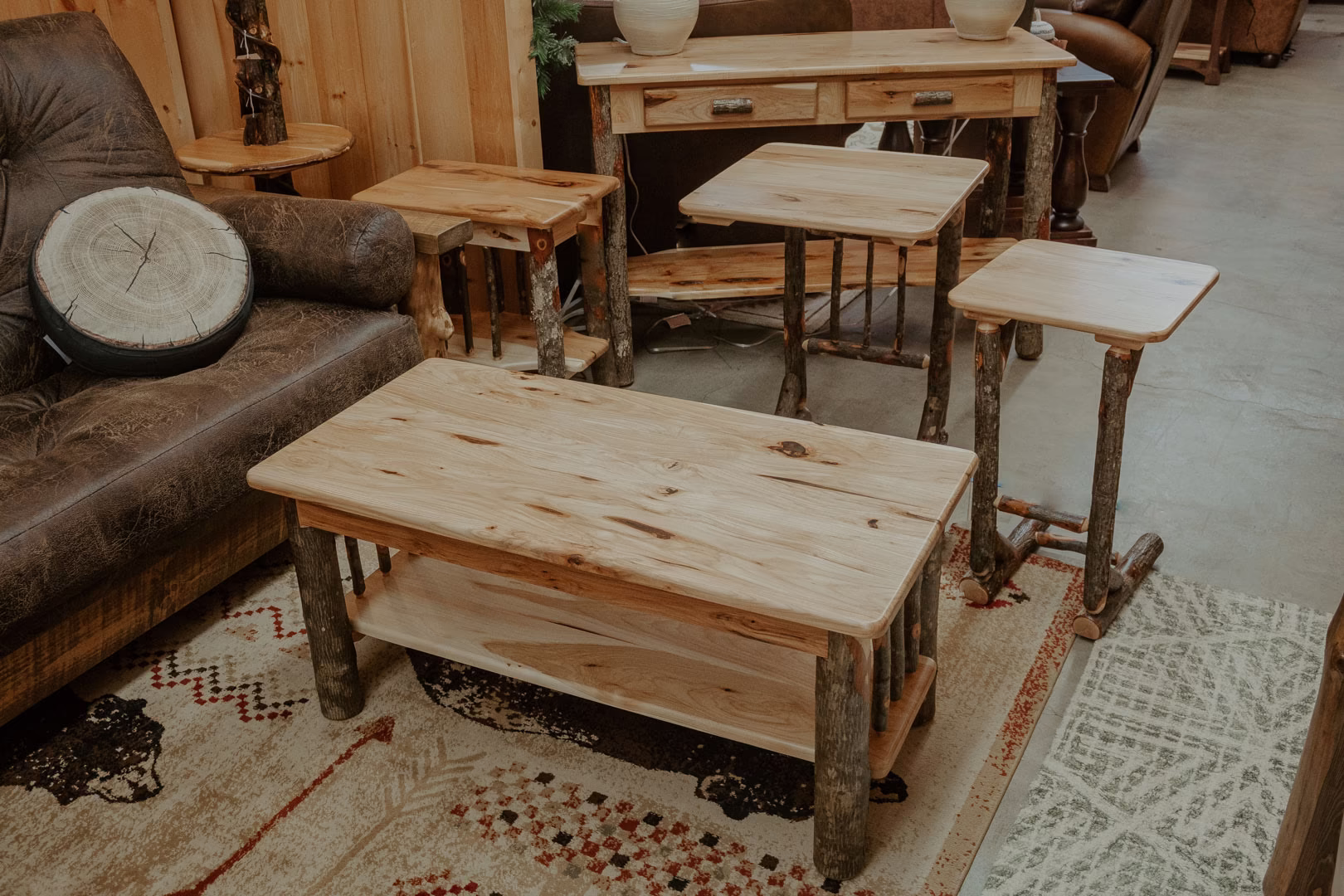 A wooden furniture store showcases a collection of a wooden coffee table, side table, end table, and bench, with a gray rug and Pleistocene-inspired design elements.