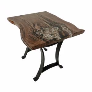 A dark brown wooden table with a black metal base and white flowers, arranged in an asymmetrical manner, creates a visually striking contrast.