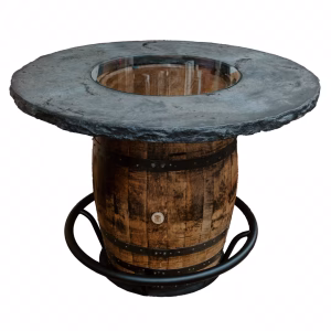 A wooden barrel with a black metal hoist holds a round black-edged table, showcasing its rustic charm against a white background.