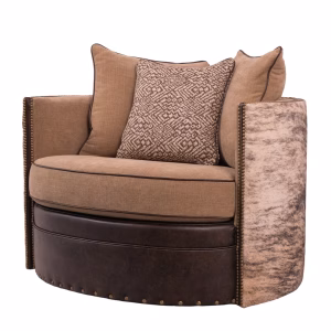 A tan and brown armchair featuring a leather nailhead-trimmed base, mixed-texture armrests, and three decorative pillows.