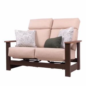 A light pink reclining loveseat with a dark brown wooden frame, accented by two white patterned throw pillows and one dark green pillow.