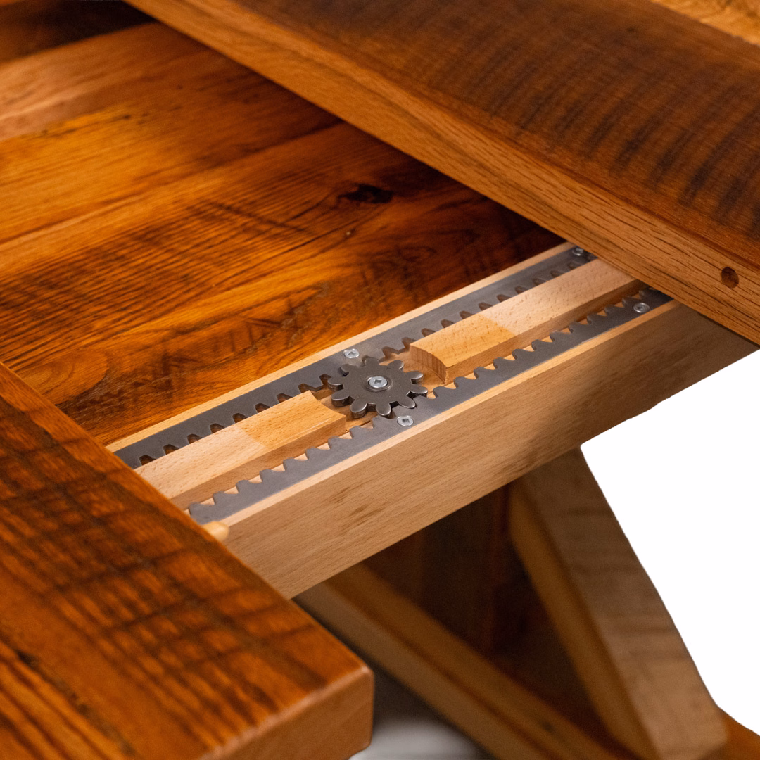 Close-up of a metal gear and rack-and-pinion mechanism integrated into a wooden table.
