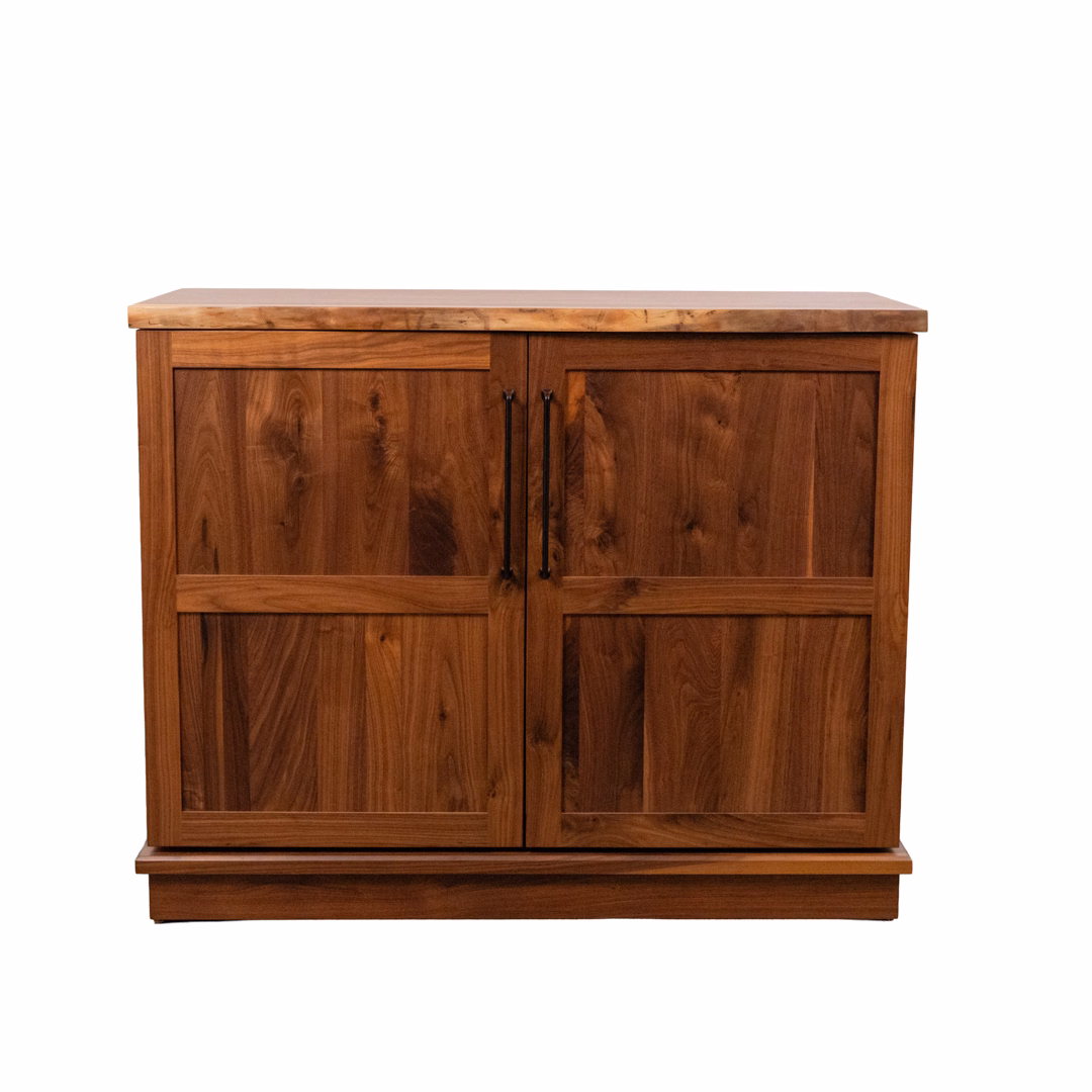 A brown wooden cabinet with two paneled doors and black handles.