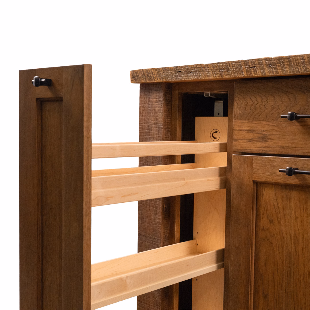 A close-up of a brown wooden cabinet with an open door revealing a built-in pull-out shelving organizer.